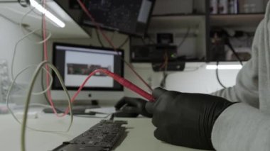 Tamir atölyesinde elektronik yenileme, çoklu metre kullanarak ana karttaki elektrik akımını test etme. Yakın çekim.