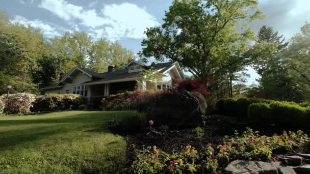 Houten huis in de tuin van de bloemen in de zomer, Breed schot — Stockvideo