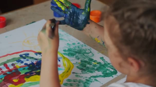 Kinder malen Hände mit Farben und das Kind legt einen Handabdruck auf das Papier — Stockvideo