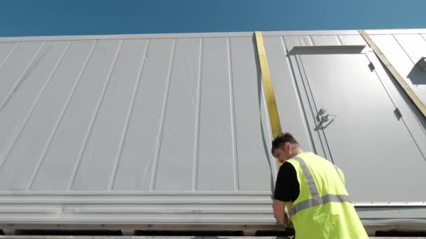 Vrachtvervoer. Mannen maken de lading vast op de truck. Breed schot — Stockvideo