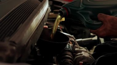 Bakım arabasının garajındaki motora yağ dökme görüntüsünü kapat