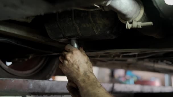 Vista de cerca de los desagües de aceite viejo del motor para el reemplazo en el garaje del coche de mantenimiento — Vídeos de Stock