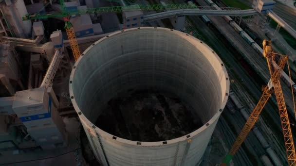 Usine de ciment avec stockage énorme en construction structure d'usine élevée à la zone de production industrielle au coucher du soleil. Vue aérienne du drone 4k — Video