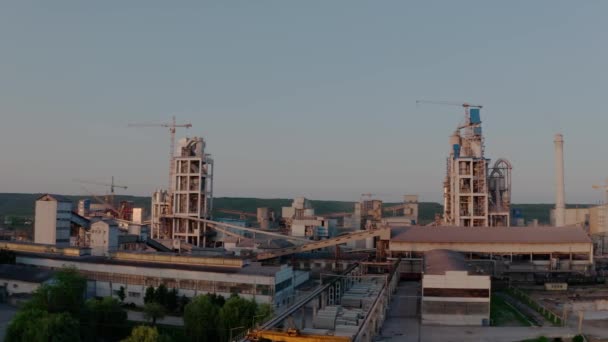Napnyugtakor az ipari termelési területen magas gyárszerkezetű cementüzem. Aerial drone nézet 4k futage — Stock videók
