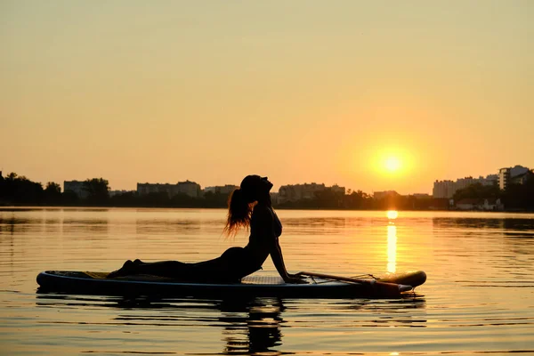 Giovane donna che fa yoga in sup board al tramonto Versione 2 — Foto Stock