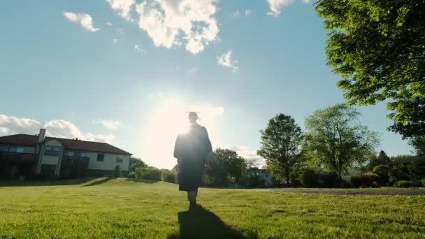 Rear view of the university graduates student at Silhouette sunset goes on the road. Slow motion shot Close up view — Vídeo de Stock