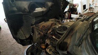 Kamyon tamirhanesi. Kamera, atölyede durduğu motor yoluna gider ve onarımları bekler.