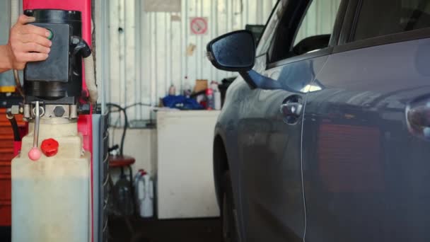 Service garage De auto op de autolift wordt opgetild voor diagnostiek en reparatie. Sluiten. — Stockvideo