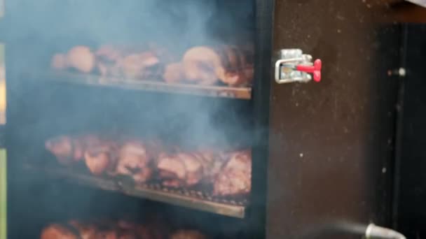 O homem abre a porta do fumeiro e verifica a temperatura da carne — Vídeo de Stock