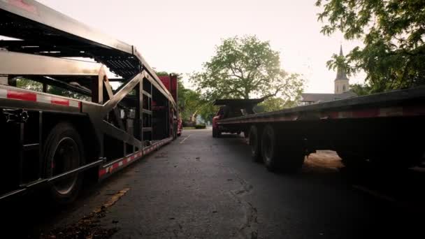 Deux camions avec un transporteur de voiture se tiennent dans le parking. Vue arrière, caméra mobile — Video