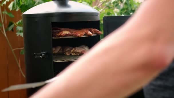 Pon carne en un ahumadero y mucho humo viene de allí. — Vídeos de Stock