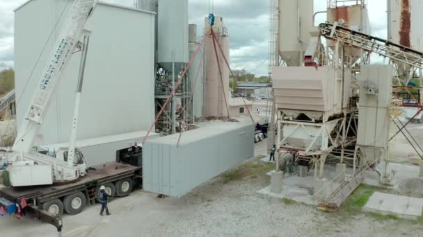 Vista aérea drone de guindaste descarrega o caminhão transportadoras na fábrica — Vídeo de Stock