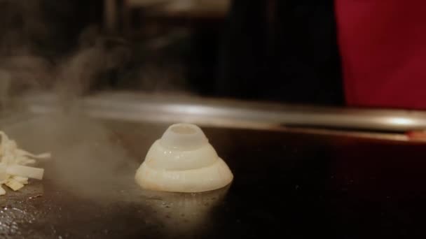 Close up view of Japanese chef cooking teppanyaki on hibachi with seafood prawns and scallops fried on hot plate. Slow motion — Vídeos de Stock