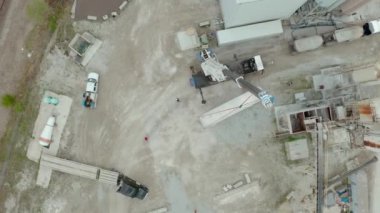 Aerial drone view of crane unloads the carriers truck at the factory. Top view