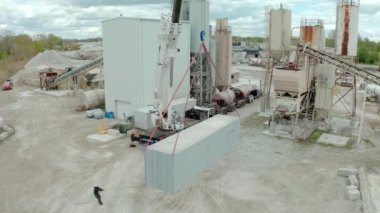 Aerial drone view of crane unloads the carriers truck at the factory. Top view futage