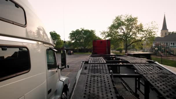 Trucks with a car hauler stand in the parking lot. Rear view futage — Wideo stockowe