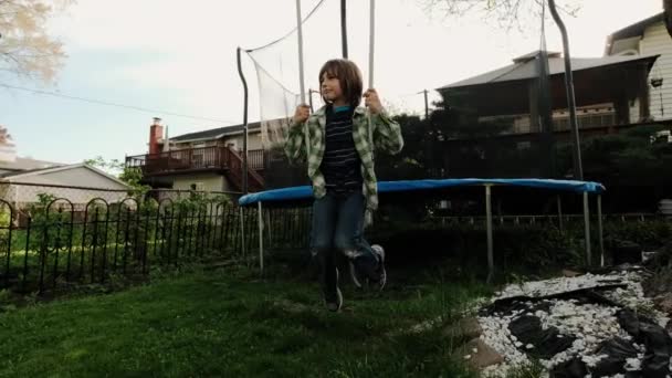 Junge vergnügt sich auf Kettenschaukel auf Spielplatz Swing Kids spielen im Freien. Weitwinkelzukunft. Zeitlupe — Stockvideo