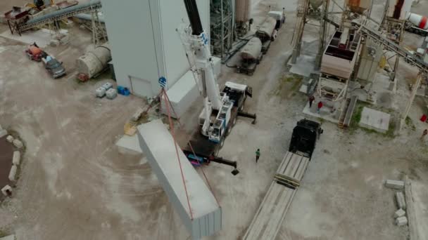 Vue aérienne par drone de la grue décharge le camion de transport à l'usine. Haut Futage large — Video