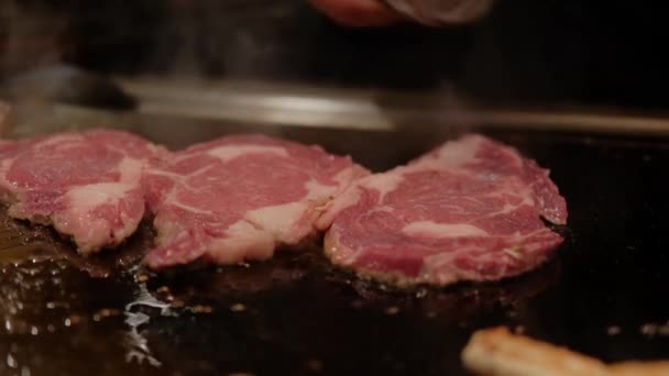 Close up.view. Японский повар готовит стейк на жареной на горячей тарелке хибачи. Медленное движение — стоковое видео