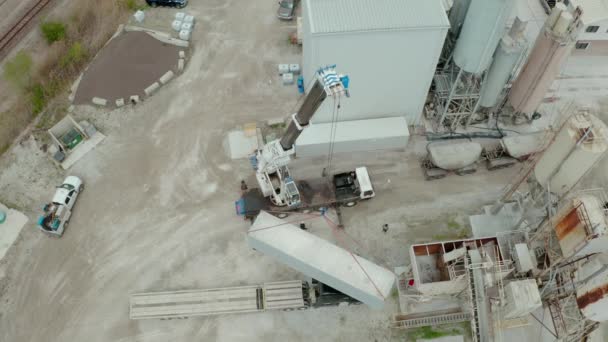 Flygdrönare syn på kranen lossar transportfartyg lastbil på fabriken. Ovanför bred framtid — Stockvideo