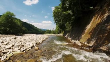 Dağlardaki güçlü nehrin kıyısında Rocky 'nin geniş bir görüntüsü.. 