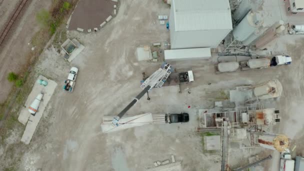 Luchtdrone zicht. Crane laadt de transportwagen uit in de fabriek. Boven Brede fusie — Stockvideo