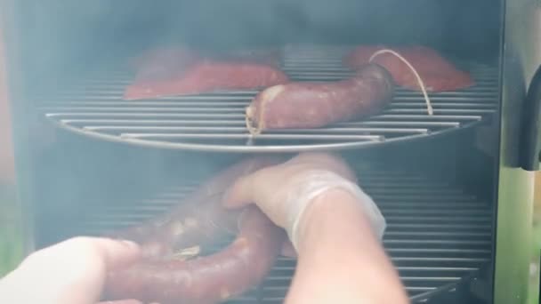 Fumar salsicha, colocar pedaços de salsicha para fumar no fumeiro. Fechar — Vídeo de Stock