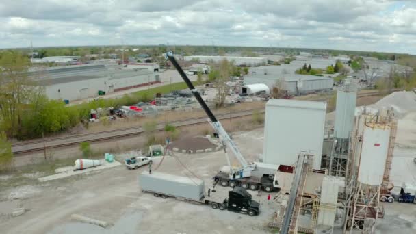 Crane scarica il camion dei trasportatori in fabbrica. Sopra ampio futage Veduta drone aereo. — Video Stock