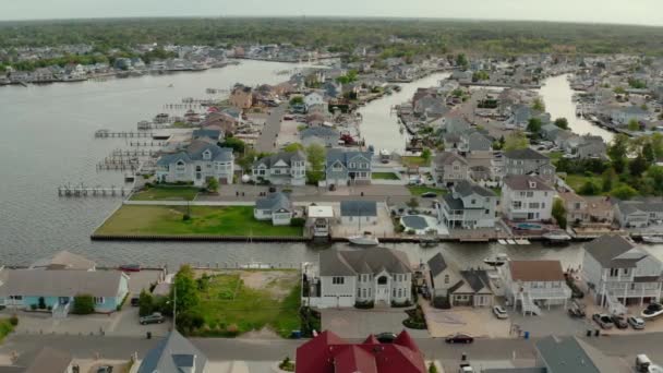 Aerial drone wide shot of local residential suburb of river in view of distant Toms River. Estados Unidos — Vídeos de Stock