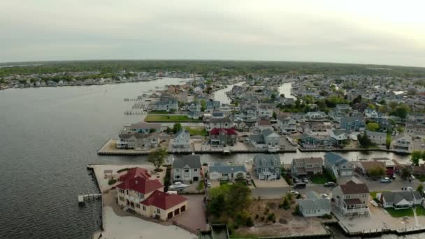 Drone wide shot of local residential suburb of river in view of distant Toms River. USA — Stock Video