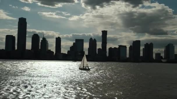 Żaglówka płynie na tle miasta, Manhattan w Nowym Jorku o zachodzie słońca. — Wideo stockowe