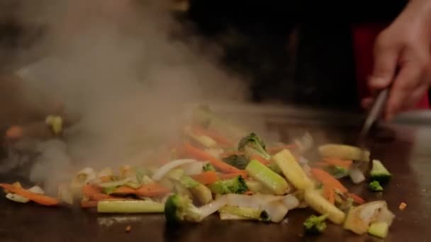 Japoński kucharz gotujący teppanyaki na hibachi. Smażone na talerzu. Powolny ruch Zamknij ujęcie — Wideo stockowe