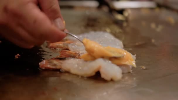 Close up visning af japansk kok madlavning rejer teppanyaki på hibachi med fisk og skaldyr rejer stegt på kogeplade. Langsom bevægelse – Stock-video