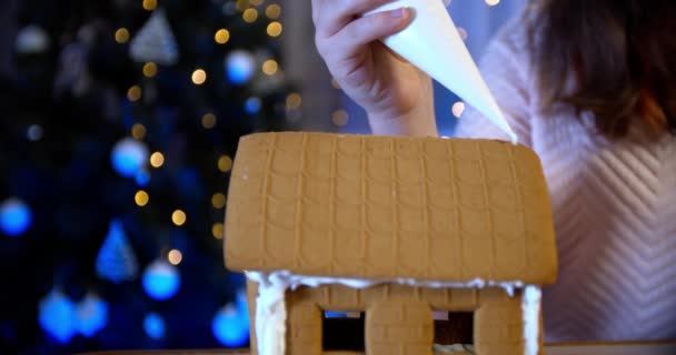 Ragazza decorare casa pan di zenzero. Tradizionale intrattenimento natalizio in famiglia. Vista da vicino — Video Stock