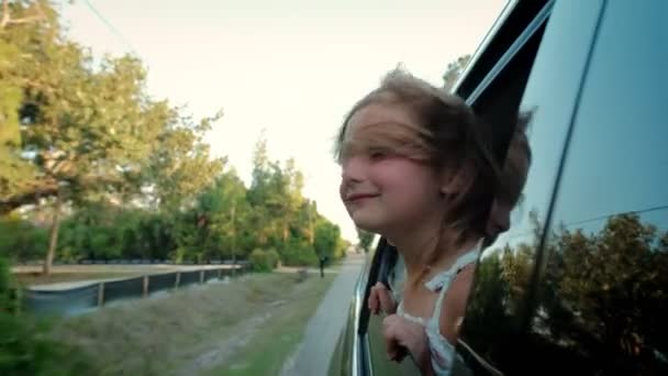 少女从车窗向外望去,挥挥手.家人乘车旅行。慢动作 — 图库视频影像