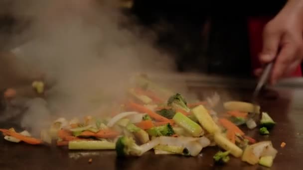 Chef japonés cocinando verduras fritas en plato caliente. Cámara lenta Primer plano tiro — Vídeos de Stock