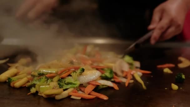 Chef japonés cocinando verduras fritas en plato caliente. Cámara lenta Vista de cerca futage — Vídeo de stock