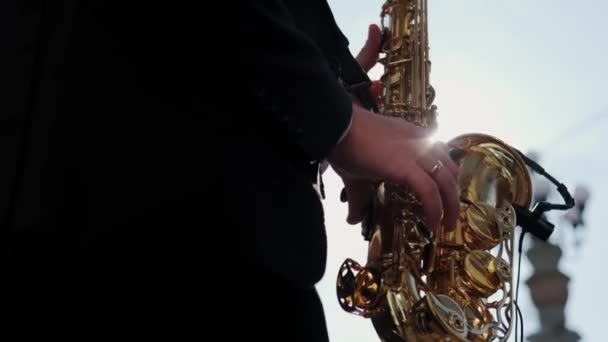 Musician saxophonist plays music on his instrument in a Sunny summer day. Close up shot — Stock Video