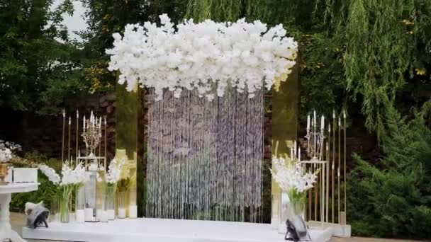 Bruiloft bloemen decoraties van bloemen in pastel vervaagde kleuren. lijst voor buiten huwelijksceremonie in park, Breed beeld — Stockvideo
