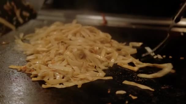 Chef japonês cozinhar legumes e massas fritas em prato quente. câmera lenta Fechar tiro — Vídeo de Stock