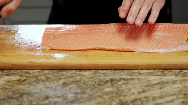 Close up futage of Cooks hands corta o peixe em pedaços para processamento posterior. Mova a câmera — Vídeo de Stock