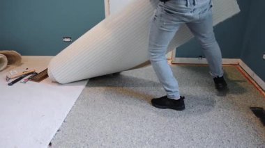 Carpenter lifting up old carpet roll and taking it away during home repair. Close up view. . High quality 4k footage