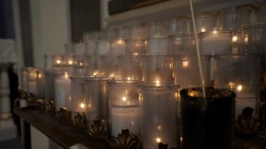 Kilisedeki mum yakma sahnesini kapatın. Kamera kenarı görüntüsü. Yüksek kalite 4k görüntü