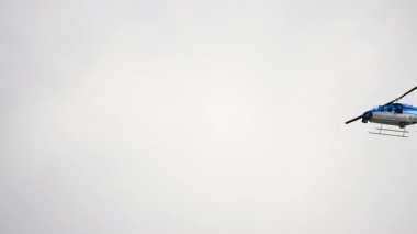 Gökyüzünde uçan bir helikopter. Bulutlu gökyüzüne karşı aşağıdan görüntü. Ağır çekim. Yüksek kalite 4k görüntü