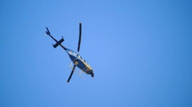 Naperville lL 'de. ABD 22 sep 2025. News Helicopter havada asılı duruyor çünkü ana pervanesi onu havada sabit tutacak kadar kaldırma gücü üretti. Açık mavi gökyüzüne karşı taban manzarası. Ağır çekim. Yüksek kalite 4k görüntü