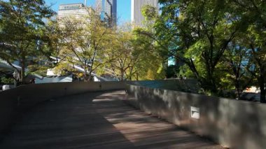 Chicago 'daki BP yaya köprüsü boyunca modern şehrin gökdelen manzarası ile yürüyoruz. Şikago İl. ABD 01 Ekim 2025. Yüksek kalite 4k görüntü