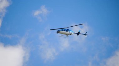 Helikopter havada süzülüyor, ana pervanesi onu havada sabit tutacak kadar kaldırma gücü üretiyor. Bulutlu gökyüzüne karşı aşağıdan görüntü. Ağır çekim. Yüksek kalite 4k görüntü