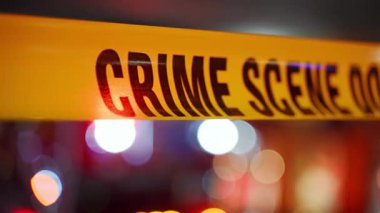 Açık sarı suç mahalli şeridini kentsel bir çevre boyunca kapatın, bu da soruşturma için yasak bölge anlamına geliyor. Arka planda parlayan polis ışıkları var. Yüksek kalite 4k görüntü