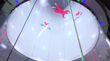 Kapalı bir hava dalışı tünelinde bir aşağı bir yukarı yüzen biri kontrollü bir serbest düşüş simülasyonu yapıyor ve tünelden kolayca çıkıyor. ABD Naperville 2 Ekim 2025. Yüksek kalite 4k görüntü