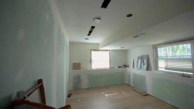 İnşaat iskelesi ve merkeze yerleştirilmiş bir el arabasıyla yenilenen bir oturma odası. Tavan yalıtımı ve tamamlanmamış alçıpan, tadilatın devam ettiğini gösteriyor. Yüksek kalite 4k görüntü